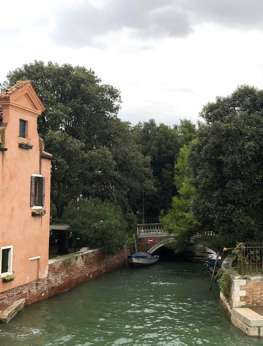 A tranquil scene of a Venice canal featuring a boat and beautiful architecture along the water's edge.